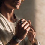 A sophisticated adult wearing discreet health technology in a calm modern setting, representing how smartwatches, smart rings, and continuous personal data are becoming part of preventive health.
